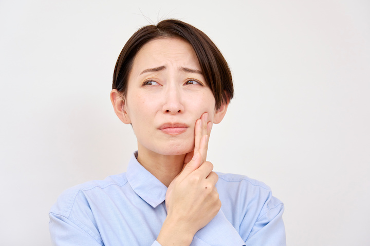 ワイヤー矯正で痛みを感じる女性