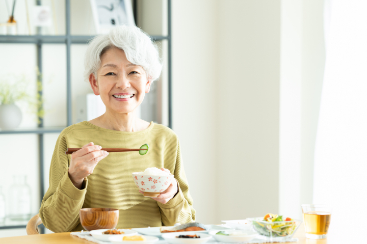 自分に合った入れ歯で食事を楽しむ女性