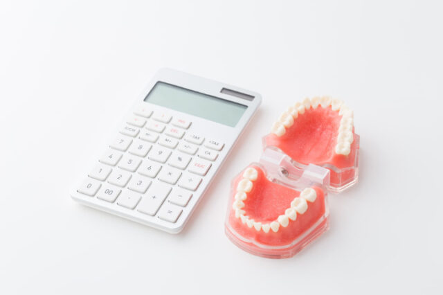 歯の模型と電卓
