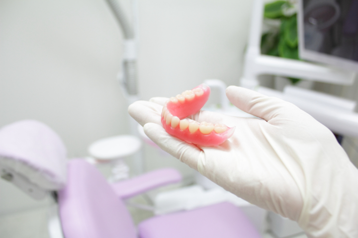入れ歯を持った歯科医師の手元