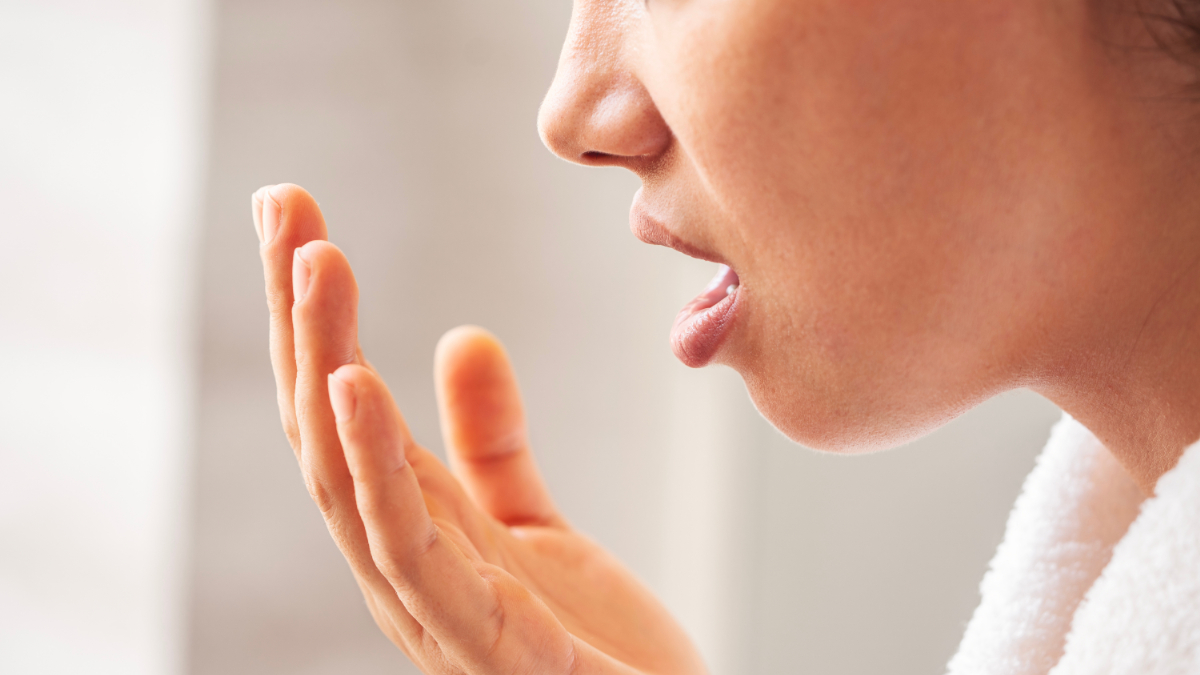 口臭があるか自分で確認している女性