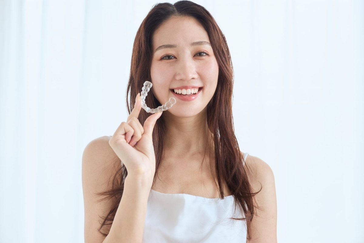 マウスピースを片手に持った笑顔の女性