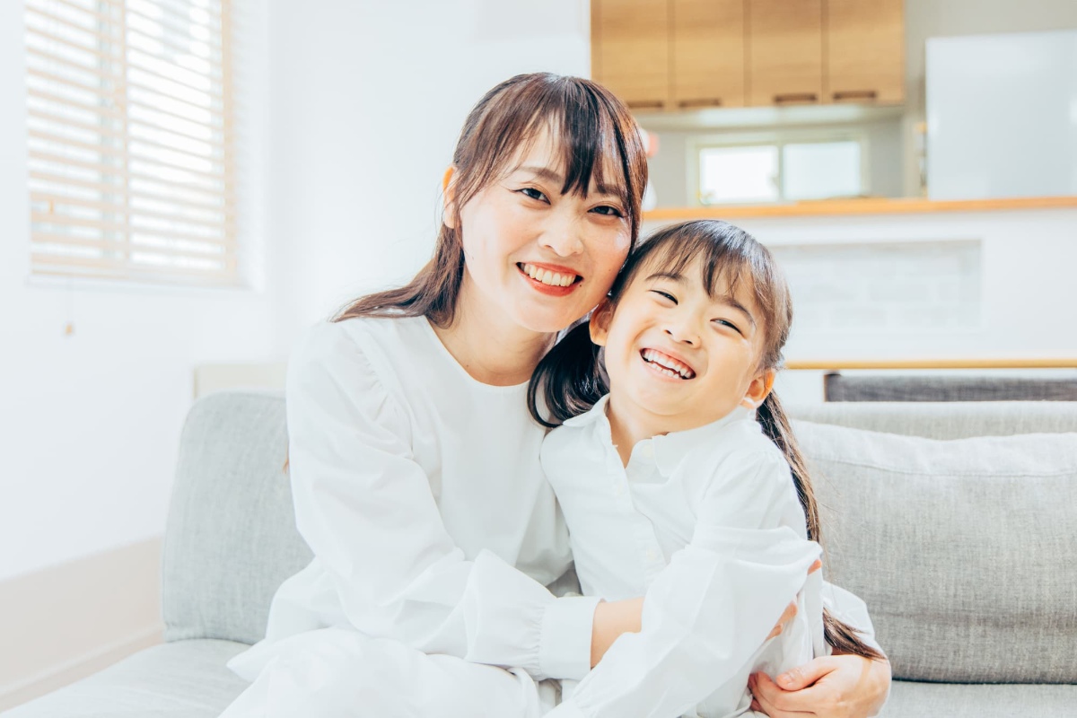 口呼吸が改善した子どもを抱いて喜ぶ母親